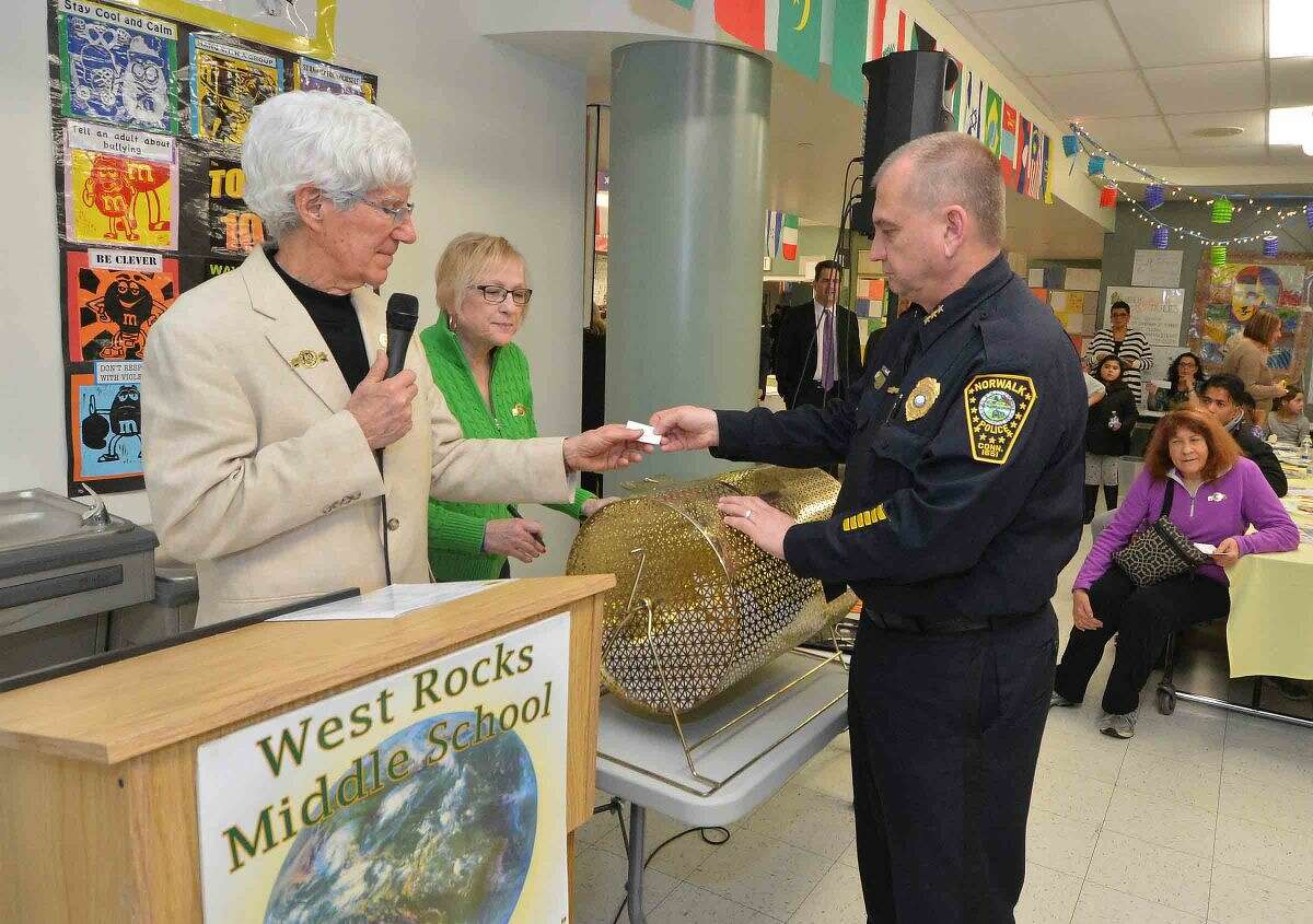 Hour Photo/Alex von Kleydorff Norwalk Police Chief Tom Kulhawik pulls some winning raffle tickets during the 12th annual Courage to Speak Empowering Youth to be Drug Free family Night at West Rocks School