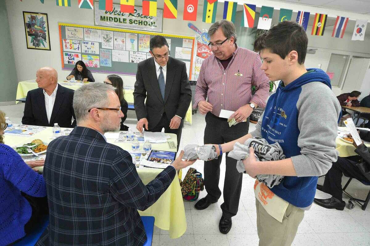 Hour Photo/Alex von Kleydorff Ric Meyer buys some raffle tickets and gets a free T-Shirt from Greg Gilbertson and Joe Boccuzzi at the 12th annual Courage to Speak Empowering Youth to be Drug Free family Night at West Rocks School