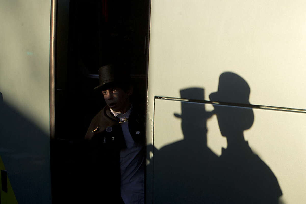 A member of the Alegre brotherhood steps off a bus upon his arrival for a mock funeral procession in Madrid, Spain, Wednesday, Feb. 18, 2015. The funeral procession traditionally marks the end the carnival. (AP Photo/Paul White)