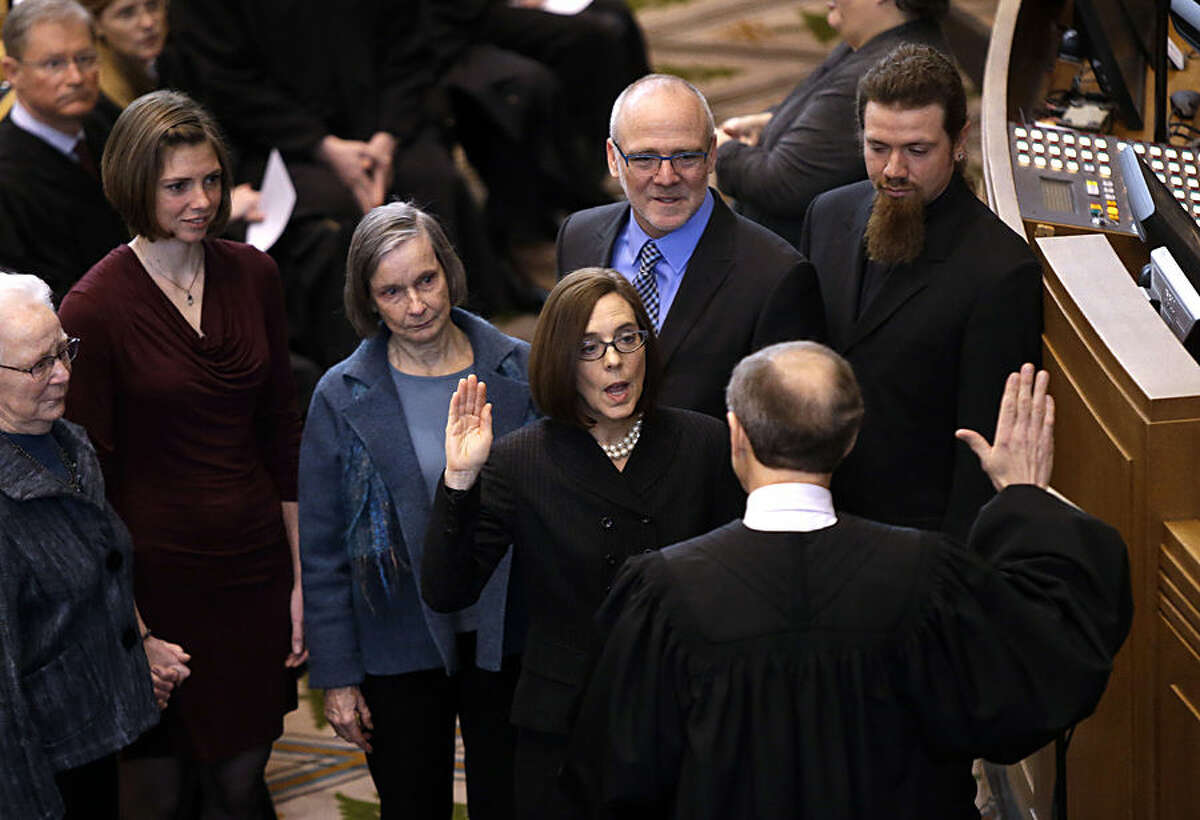 Oregon Secretary of State Kate Brown is sworn in as Oregon Governor by Oregon Chief Justice Thomas A. Balmer in Salem, Ore., Wednesday, Feb. 18, 2015. John Kitzhaber, elected to an unprecedented fourth term last year, announced last week that he would step down amid allegations his fiancee used her relationship with him to enrich herself. (AP Photo/Don Ryan)