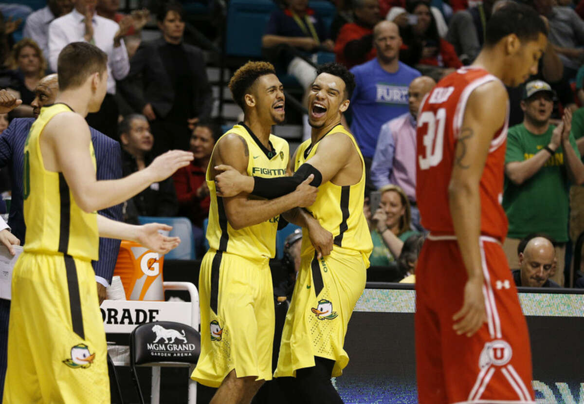Oregon guard Tyler Dorsey, center left, embraces forward Dillon Brooks as they celebrate after Oregon defeated Utah in an NCAA college basketball game in the championship of the Pac-12 men's tournament Saturday, March 12, 2016, in Las Vegas. Oregon won 88-57. (AP Photo/John Locher)