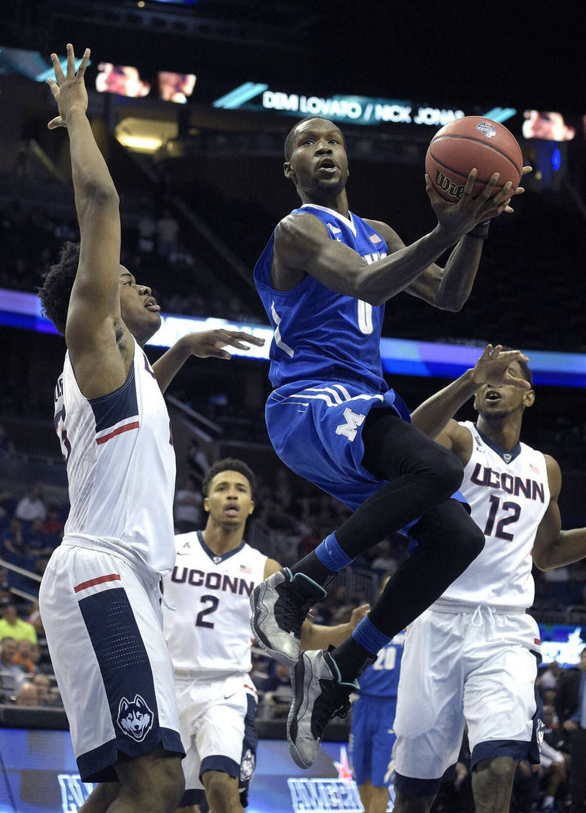 Memphis forward Trashon Burrell (0) goes up for a shot in front of Connecticut forward Steven Enoch (13), left, guard Jalen Adams (2) and forward Kentan Facey (12) during the first half of an NCAA college basketball game in the finals of the American Athletic Conference men's tournament in Orlando, Fla., Sunday, March 13, 2016. (AP Photo/Phelan M. Ebenhack)