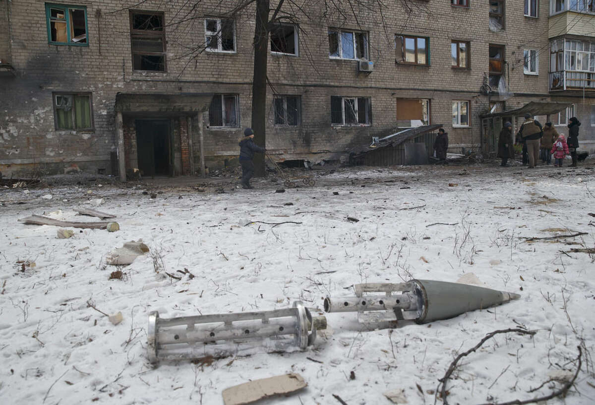 The remains of a rocket lie outside a damaged apartment building in Debaltseve, Ukraine, Friday, Feb. 20, 2015. After weeks of relentless fighting, the embattled Ukrainian rail hub of Debaltseve fell Wednesday to Russia-backed separatists, who hoisted a flag in triumph over the town. The Ukrainian president confirmed that he had ordered troops to pull out and the rebels reported taking hundreds of soldiers captive.(AP Photo/Vadim Ghirda)