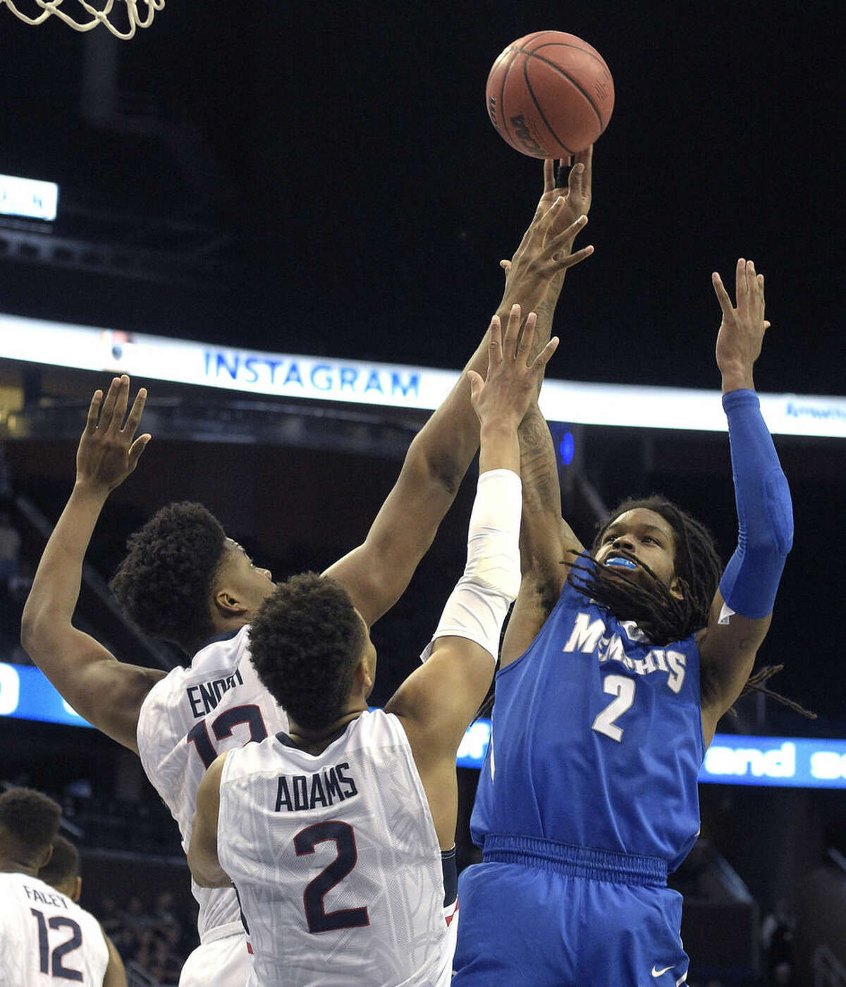 Memphis forward Shaq Goodwin (2) goes up for a shot in front of Connecticut forward Steven Enoch (13) and guard Jalen Adams (2) during the first half of an NCAA college basketball game in the finals of the American Athletic Conference men's tournament in Orlando, Fla., Sunday, March 13, 2016. (AP Photo/Phelan M. Ebenhack)