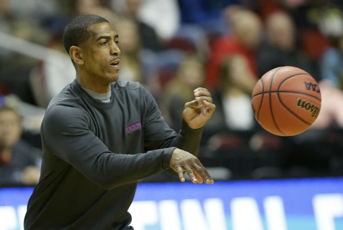 Connecticut head coach Kevin Ollie passes the ball during practice for a first-round men's college basketball game in the NCAA Tournament , Wednesday, March 16, 2016, in Des Moines, Iowa. Connecticut will play Colorado on Thursday. (AP Photo/Charlie Neibergall)