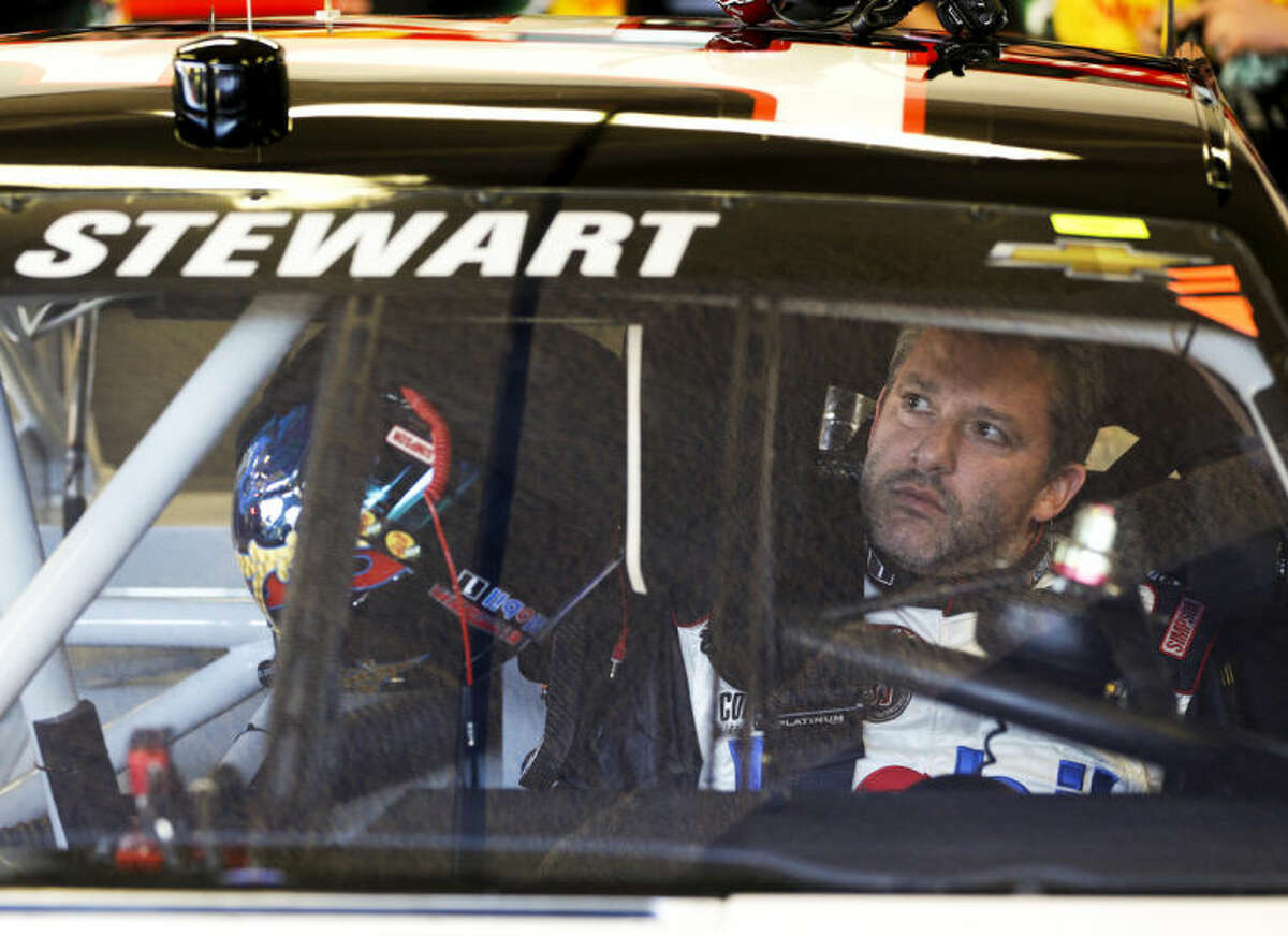 Driver Tony Stewart adjusts the rear view mirror in his car before going out on the track to practice for the NASCAR Sprint Unlimited auto race at Daytona International Speedway in Daytona Beach, Fla., Friday, Feb. 14, 2014. Stewart has not raced in more than six months since he broke two bones in his leg in an August 2013 sprint-car crash.(AP Photo/John Raoux)