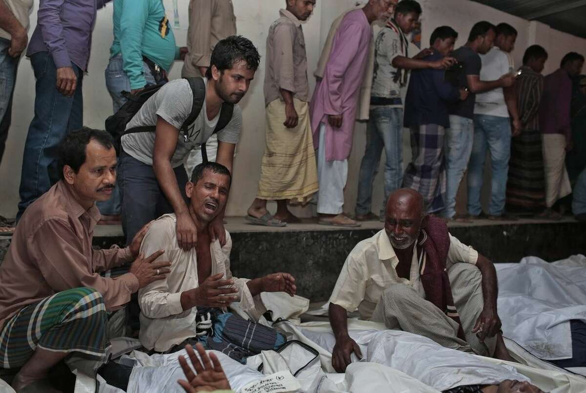 Bangladeshi relatives wail near bodies of victims after a river ferry carrying about 100 passengers capsized Sunday after being hit by a cargo vessel,in Manikganj district, about 40 kilometers (25 miles) northwest of Dhaka, Bangladesh, Sunday, Feb. 22, 2015. It is yet not clear how many people are missing.(AP Photo/ A.M. Ahad)