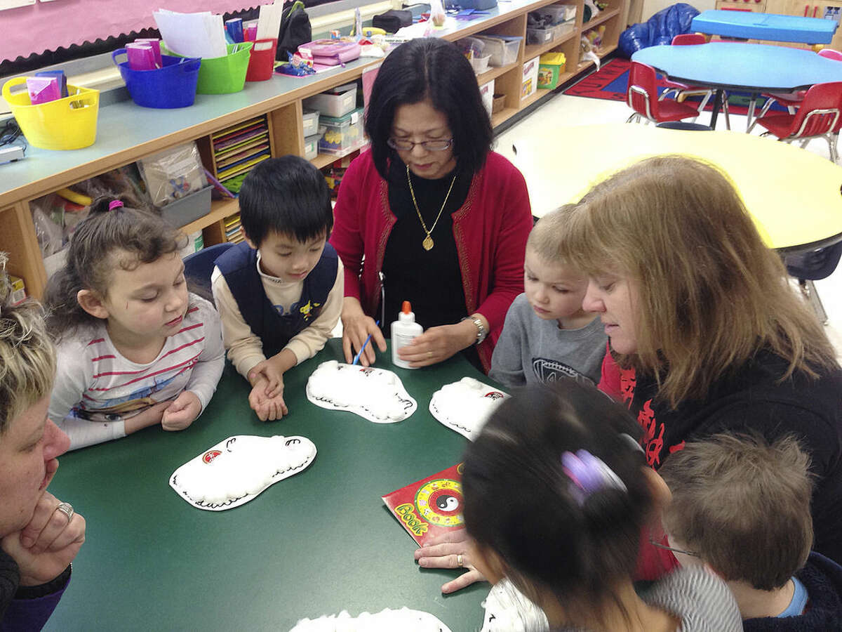 In this Feb. 19, 2015 photo, from left, Skyler Demars, Kevin Hu, Mandarin teacher Shwu-Ching Wang, Hunter Hatch and kindergarten teacher Lisa Halloran decorate sheep in honor of the Lunar New Year at the Mohegan Elementary School in Montville, Conn. At Connecticut’s casinos, the staff can speak to you in nearly any Asian language. The diversity of the workforce at the casinos, which cater heavily to Asian gamblers from New York, is changing the complexion of nearby public schools that have been hiring more language specialists and adding new cultural traditions. (AP Photo/Michael Melia)