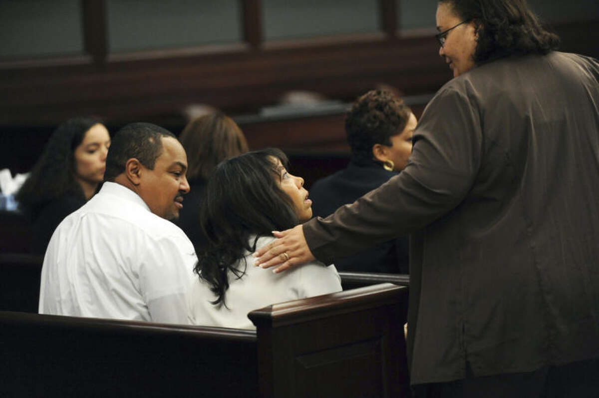 Lucia McBath, center, mother of Jordan Davis, is greeted by an unidentified woman who sat with the family in the courtroom, Saturday, Feb. 15, 2014 in Jacksonville, Fla. Her husband, Curtis McBath sits to her left. A jury begins their fourth day of deliberations Saturday in the trial of Michael Dunn, who is charged with fatally shooting 17-year-old Jordan Davis after an argument over loud music outside a Jacksonville convenient store in 2012. As of Friday, they had deliberated for 22 hours over three days. (AP Photo/The Florida Times-Union, Bob Mack, Pool)