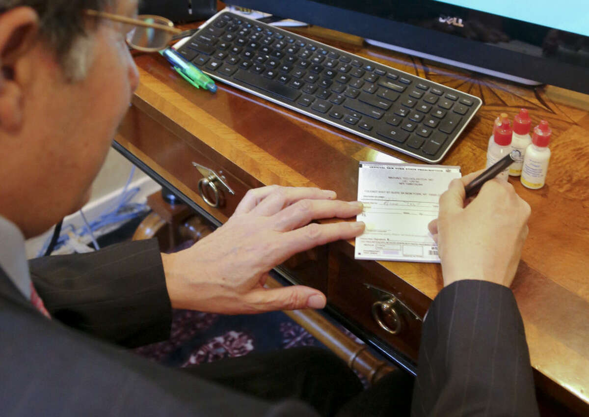 Dr. Michael T. Goldstein, New York County Medical Society President, use a standard prescription pad which is being made obsolete by a new electronic prescription law, Thursday, March 17, 2016, in New York. E-prescribing has surged nationwide in recent years. Every state now allows it, but only New York has a broad requirement that carries penalties. (AP Photo/Bebeto Matthews)