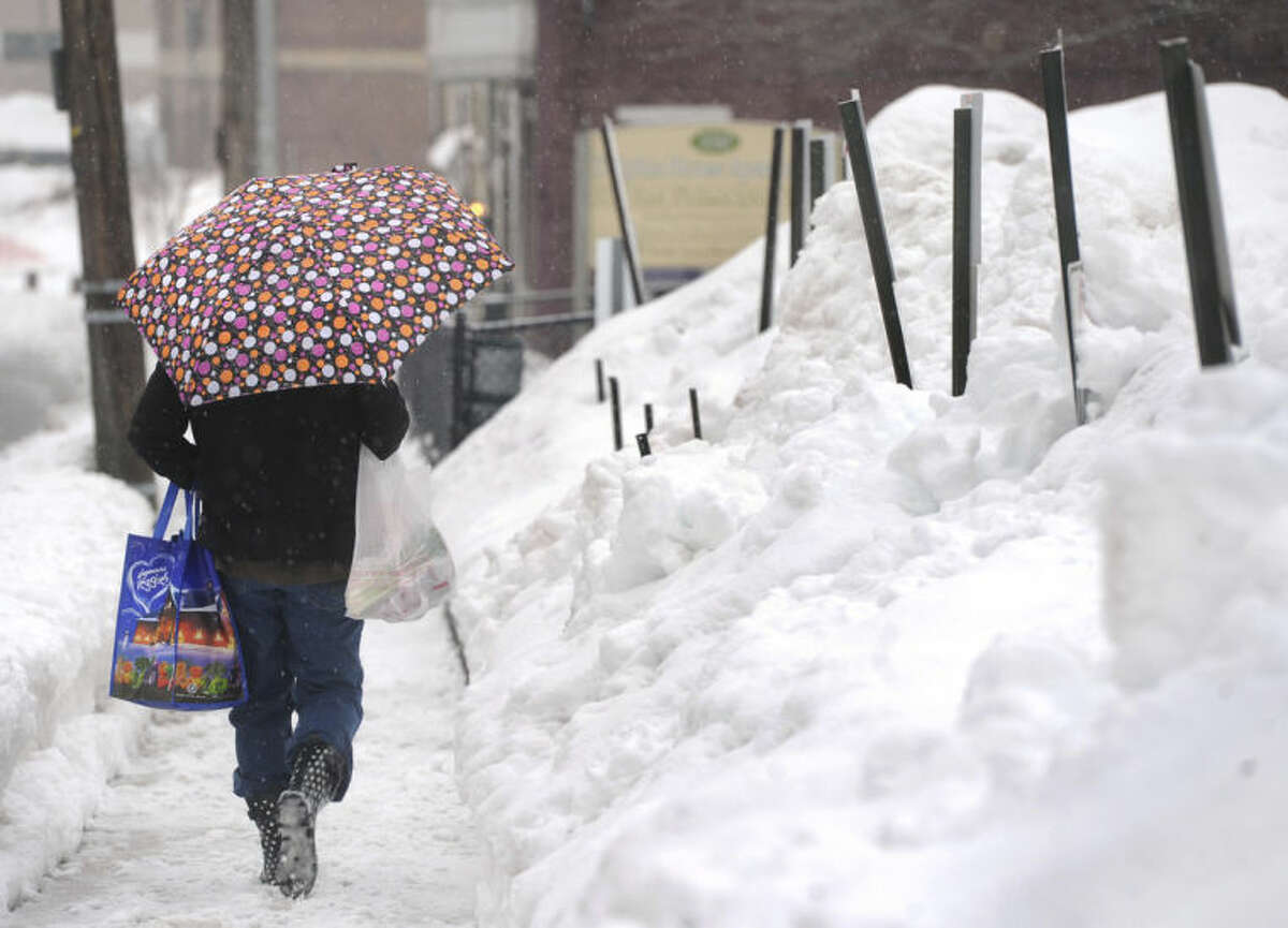 AP Photo/York Daily Record, Jason Plotkin Pam Yeaple walks home along East Philadelphia Street after grocery shopping in York, Pa. on Saturday, Feb. 15, 2014. An inch of new snow had fallen by mid-day in much of eastern Pennsylvania on Saturday.