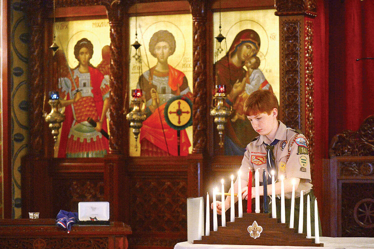 Hour photo / Erik Trautmann A boy scout performs the Lighting of Scout Law and Oath Candles as Sean Walters is honored during the Boy Scout Eagle Court of Honor ceremony at St. George Greek Orthodox Church where Walters was awarded the Eagle Scout Badge with the help of his family and dignitaries Saturday afternoon.