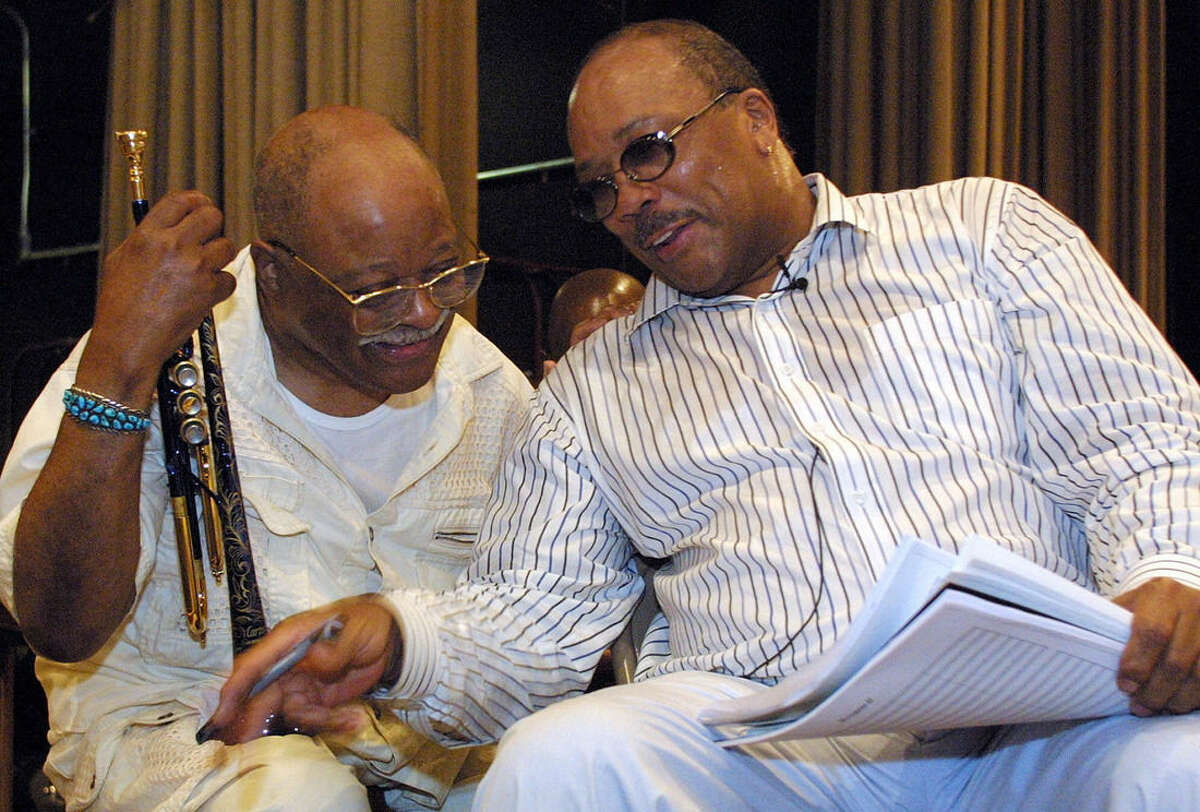 File-This June 13, 2001, file photo shows Quincy Jones, right, talking with jazz musician Clark Terry at a rehearsal of "Sonic Convergence," in New York. Terry, a legendary jazz trumpeter, who mentored Miles Davis and Jones and played in the orchestras of both Count Basie and Duke Ellington and on "The Tonight Show," has died. He was 94. (AP Photo/Stuart Ramson, File)