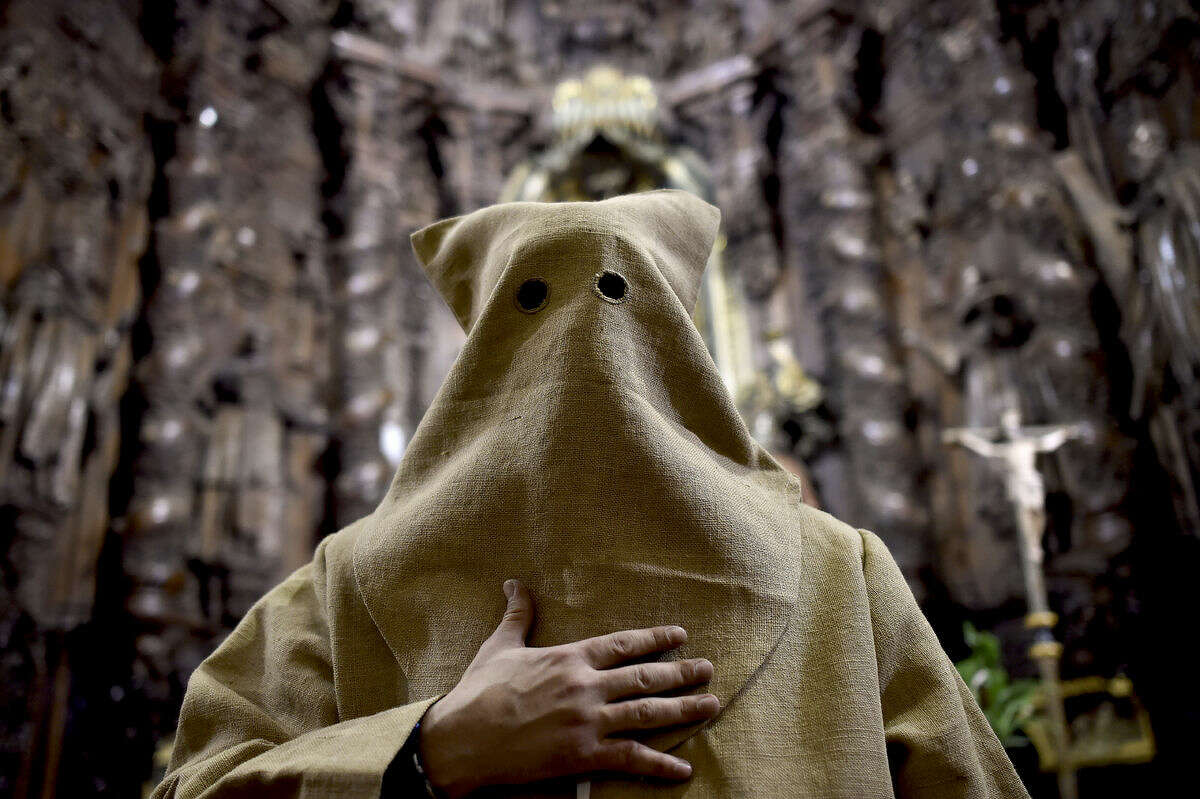 An 'Ensacado,'' or masked penitent, takes part in the procession of the "Silencio del Santisimo Cristo del Rebate" brotherhood, during Holy Week in Tarazona, northern Spain, Tuesday, March 22, 2016. Hundreds of processions take place throughout Spain during the Easter Holy Week. (AP Photo/Alvaro Barrientos)