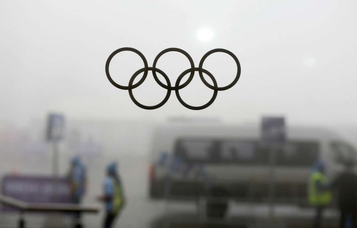 Olympic rings on a window are silhouetted against thick fog at the Laura Biathlon centre at the 2014 Winter Olympics, Monday, Feb. 17, 2014, in Krasnaya Polyana, Russia. The men?’s 15-kilometer mass-start biathlon race at the Sochi Olympics has been delayed due to fog, one day after the event had been called off for the same reason. (AP Photo/Felipe Dana)