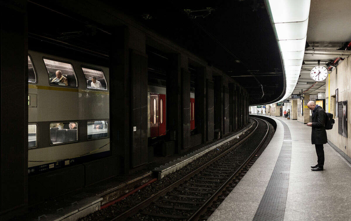 A man waits on an empty train platform at the Central Station in Brussels on Wednesday, March 23, 2016. Belgian authorities were searching Wednesday for a top suspect in the country's deadliest attacks in decades, as the European Union's capital awoke under guard and with limited public transport after 34 were killed in bombings on the Brussels airport and a subway station. (AP Photo/Valentin Bianchi)