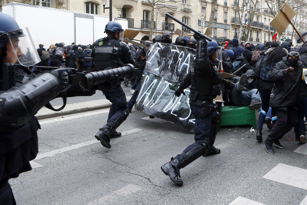 Youths clash with riot police officers during a high school students demonstration against a labor reform, in Paris, Thursday, March 24, 2016. France's Socialist government is due to formally present a contested labor reform that aims to amend the 35-hour workweek and relax other labor rules.(AP Photo/Francois Mori)