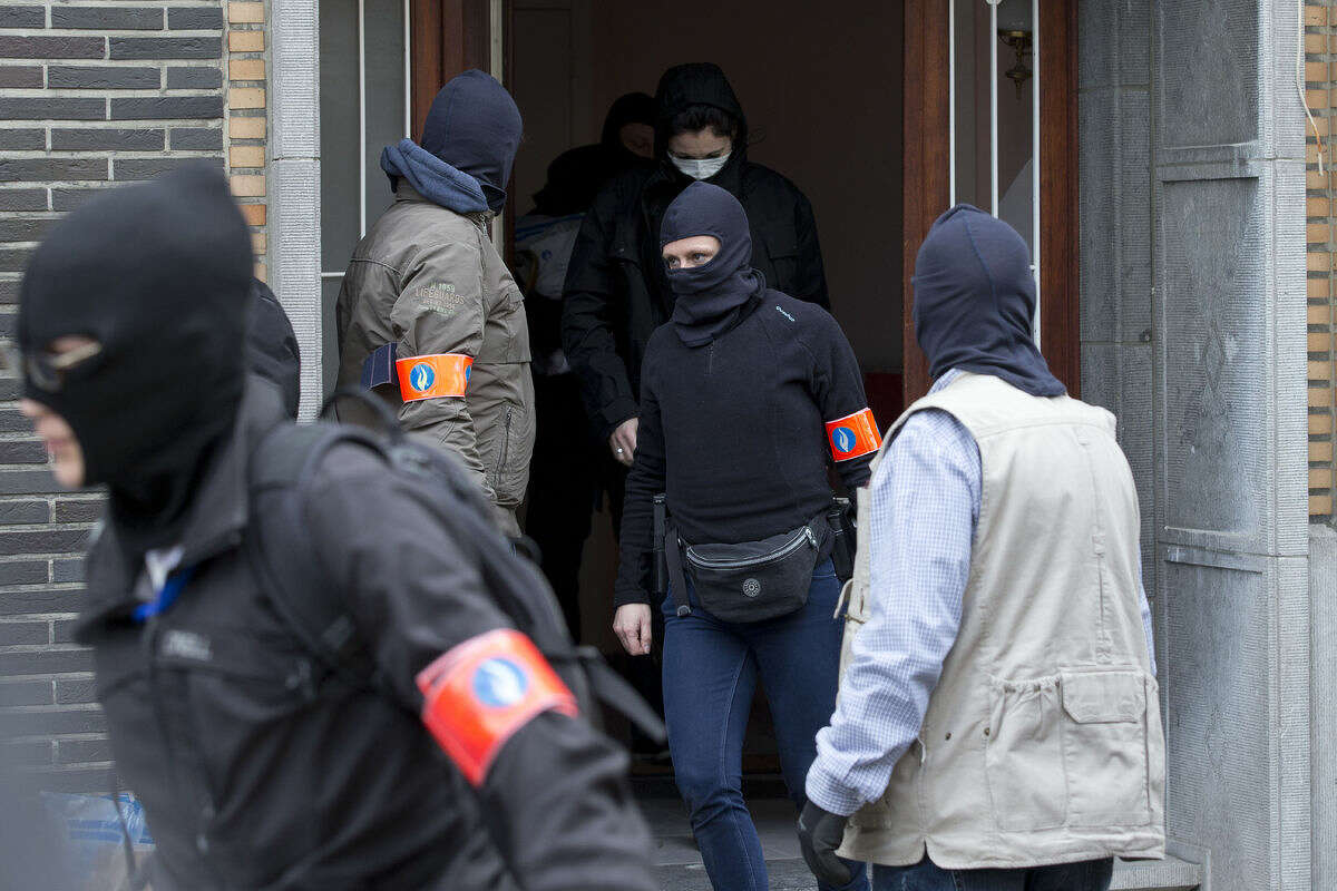 Belgian police leave after an investigating in a house in the Anderlecht neighborhood of Brussels, Belgium, Wednesday, March 23, 2016, one day after Tuesday's deadly suicide attacks on the Brussels airport and its subway system. (AP Photo/Peter Dejong)