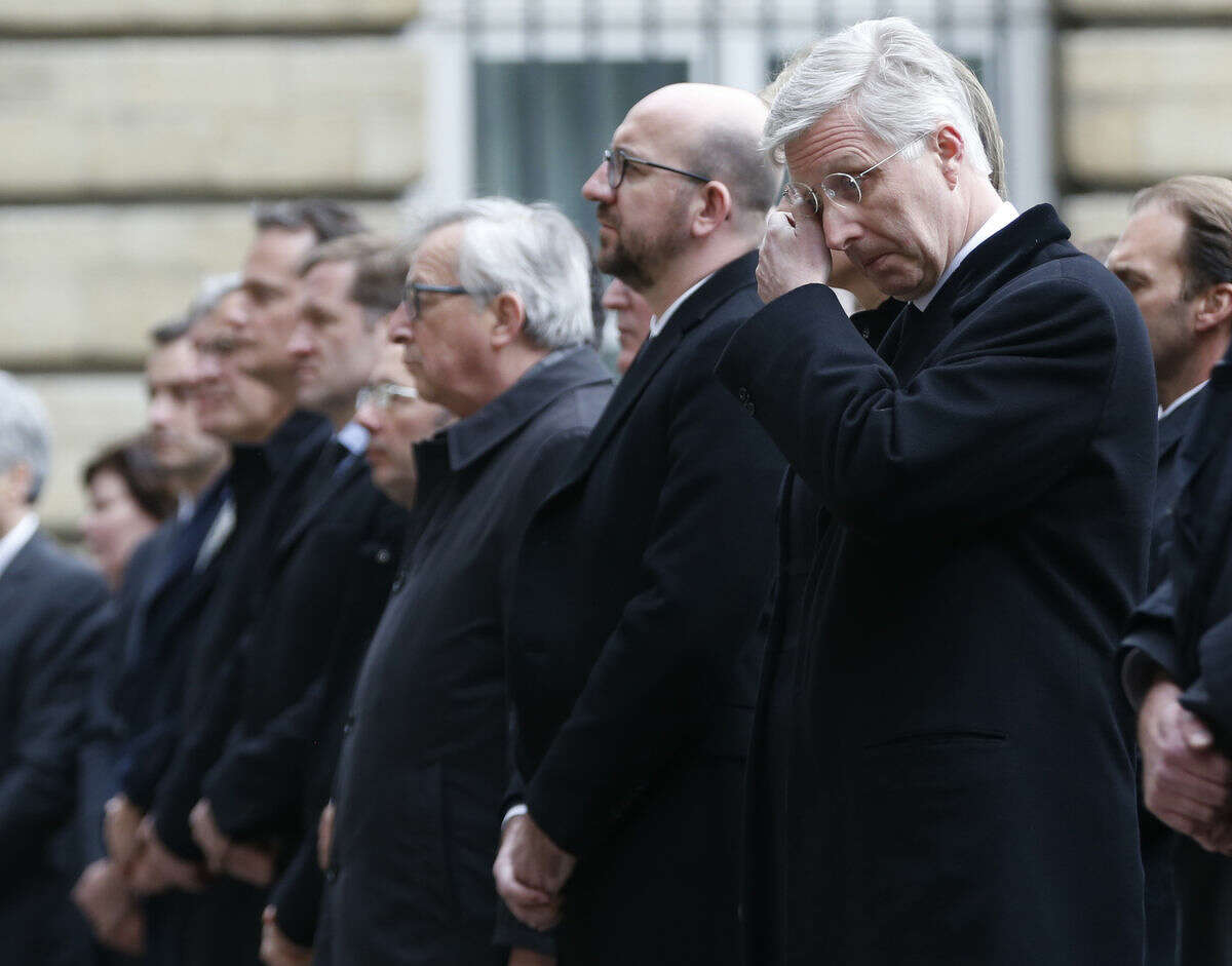 Belgium's King Philippe, right, wipes his eyes as he stands next to Belgium's Prime Minister Charles Michel during a service in grounds of the Parliament building, in memory of the victims of the recent attacks in Belgium, Thursday, March, 24, 2016. Belgium's prime minister is promising to do everything to determine who was responsible for deadly attacks targeting the Brussels airport and subway system. Charles Michel, in a national mourning speech Thursday, said Tuesday's attacks on the European Union's capital targeted the "liberty of daily life" and "the liberty upon which the European project was built." (AP Photo/Alastair Grant)