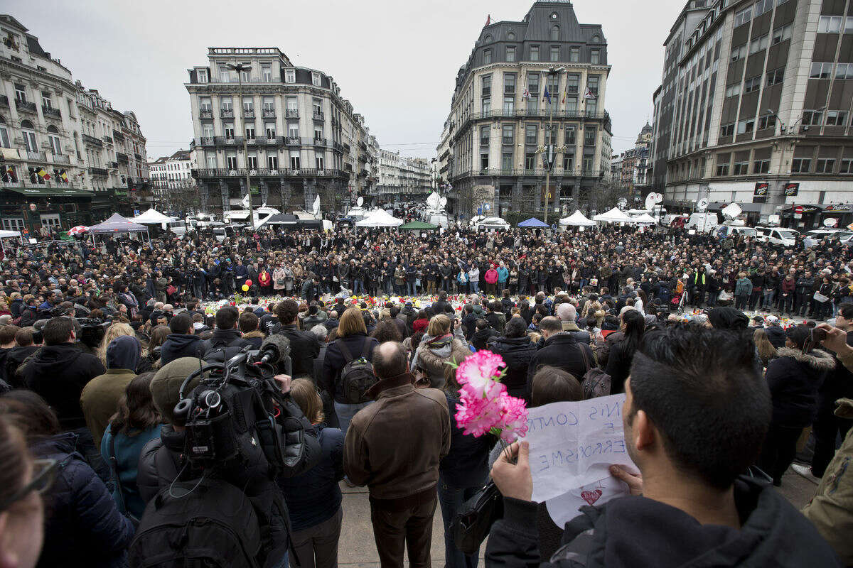People gathered to observe a minute of silence and mourn for the victims of the bombings at the Place de la Bourse in the center of Brussels, Belgium, Thursday, March 24, 2016. The Islamic State group has trained at least 400 fighters to target Europe in deadly waves of attacks, deploying interlocking terror cells like the ones that struck Brussels and Paris with orders to choose the time, place and method for maximum carnage. (AP Photo/Peter Dejong)