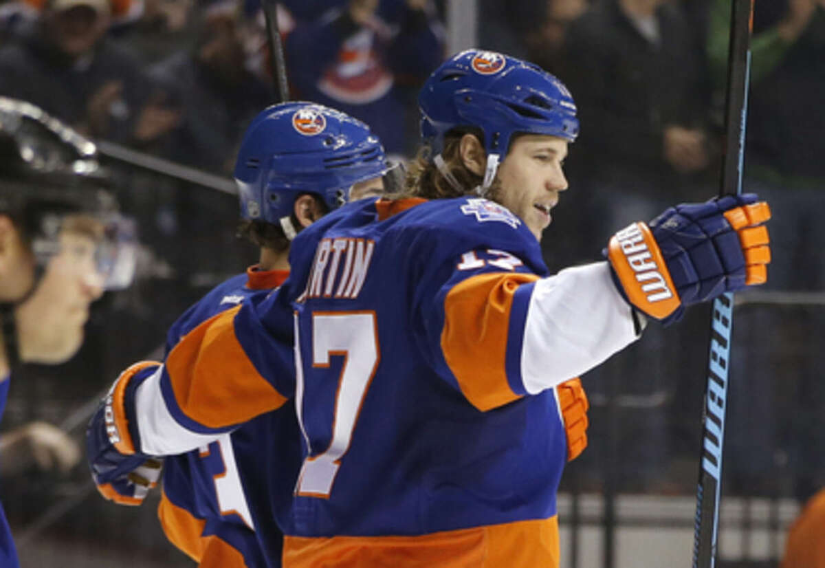 New York Islanders left wing Matt Martin (17) celebrates with a teammate after scoring the second of three Islanders goals in the second period of an NHL hockey game against the Ottawa Senators in New York, Wednesday, March 23, 2016. (AP Photo/Kathy Willens)