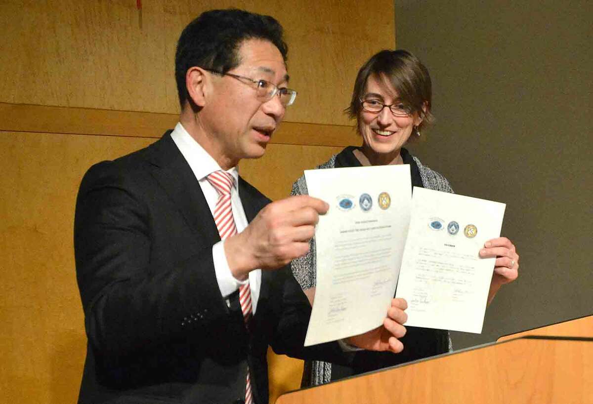 Hour Photo/Alex von Kleydorff Kojo High school Principal Takahisa and Center for Global Studies Director Julie Parham sign and present Sister School documents during an Friendship Exchange Renewal program at the center Thursday night