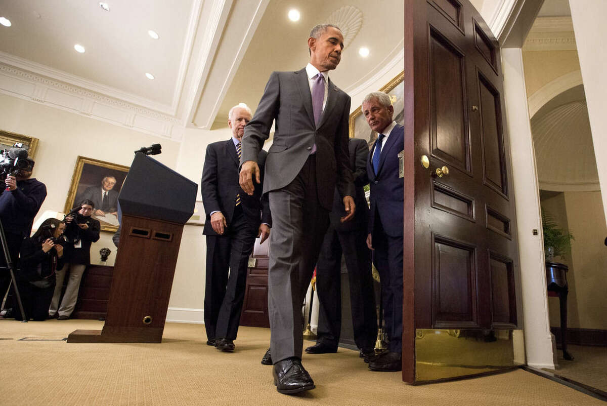 President Barack Obama leaves the Roosevelt Room of the White House in Washington, Wednesday, Feb. 11, 2015, followed by Vice President Joe Biden, left, Secretary of State John Kerry, obscured, and Defense Secretary Chuck Hagel, after speaking about the Islamic State group. Obama asked the U.S. Congress on Wednesday to authorize military force to "degrade and defeat" Islamic State forces in the Middle East without sustained, large-scale U.S. ground combat operations, setting lawmakers on a path toward their first war powers vote in 13 years. (AP Photo/Jacquelyn Martin)