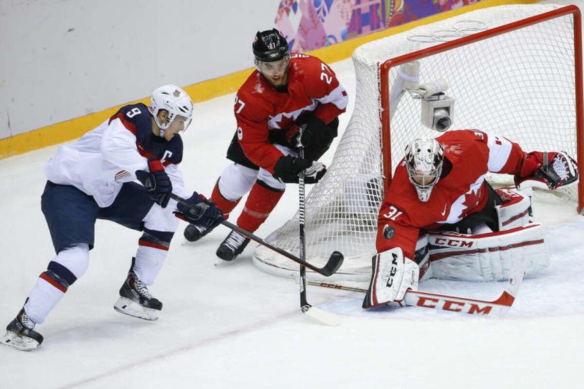 Canada goaltender Carey Price blocks a shot at the goal by USA forward Zach Parise as Canada defenseman Alex Pietrangelo skates into help protect the goal during the men's semifinal ice hockey game at the 2014 Winter Olympics, Friday, Feb. 21, 2014, in Sochi, Russia. (AP Photo/Matt Slocum)
