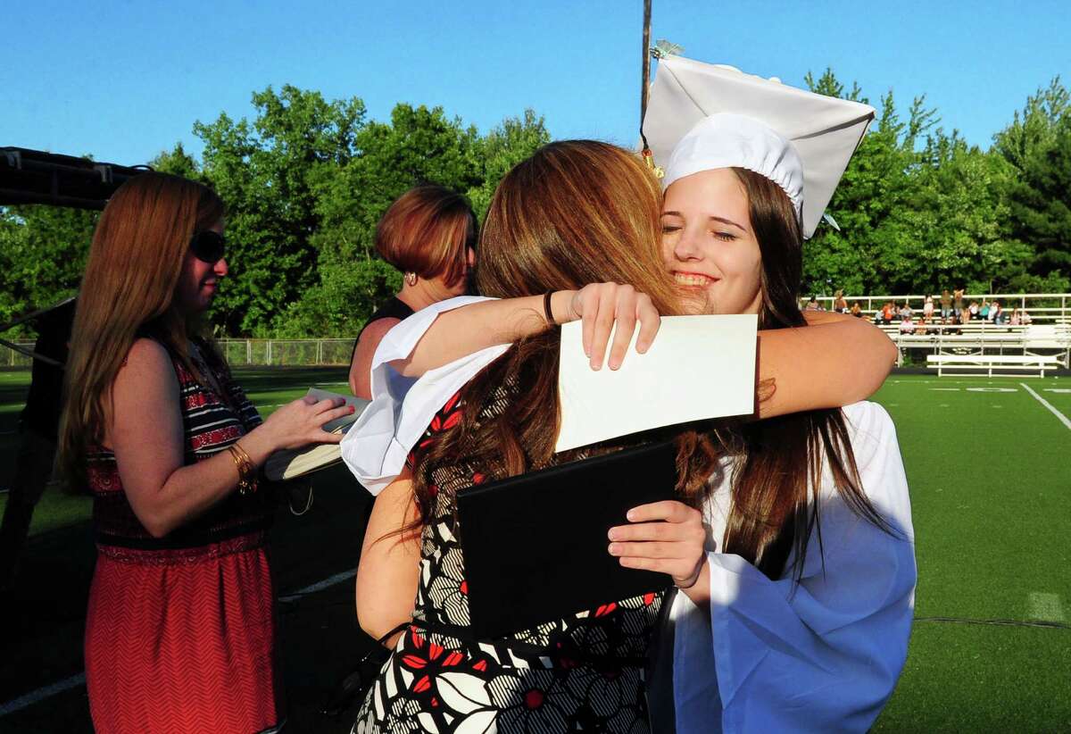 Graduate Taylor Blakenship hugs her teacher after getting her diploma during Shelton High School's Class of 2016 Commencement Exercises in Shelton, Conn., on Friday June 10, 2016.