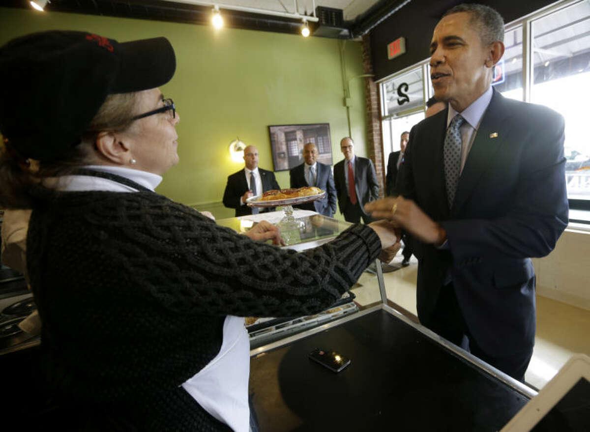 President Barack Obama greets owner Alice Bruno during his unannounced visit to Café Beauregard in New Britain, Conn., Wednesday, March 5, 2014. Obama traveled to Hartford, Conn., area to highlight the importance of raising the minimum wage and then will travel to Boston for a pair of Democratic fundraising. (AP Photo/Pablo Martinez Monsivais)