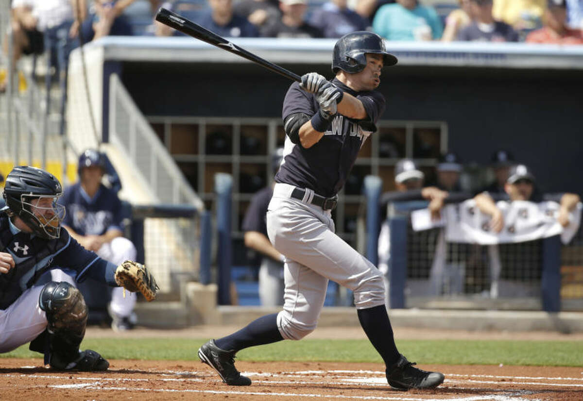 New York Yankees' Ichiro Suzuki, right, singles as Tampa Bay Rays catcher Ryan Hanigan, left, looks on in the first inning of an exhibition baseball game, Wednesday, March 5, 2014, in Port Charlotte, Fla. (AP Photo/Steven Senne)