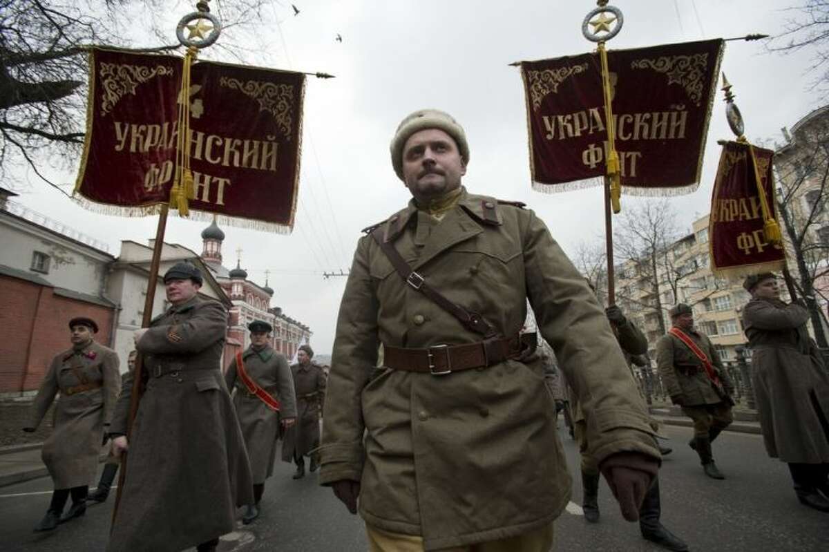 Pro-Kremlin demonstrators dressed in WWII army uniforms and carrying replicas of Soviet Army WWII banners reading, Ukrainian Front, march in central Moscow, Russia, Sunday, March 2, 2014 to express support for the latest developments in Russian-Ukrainian relations. Banners are those of units that were liberating Ukraine from Nazi occupation during WWII. (AP Photo/Pavel Golovkin)