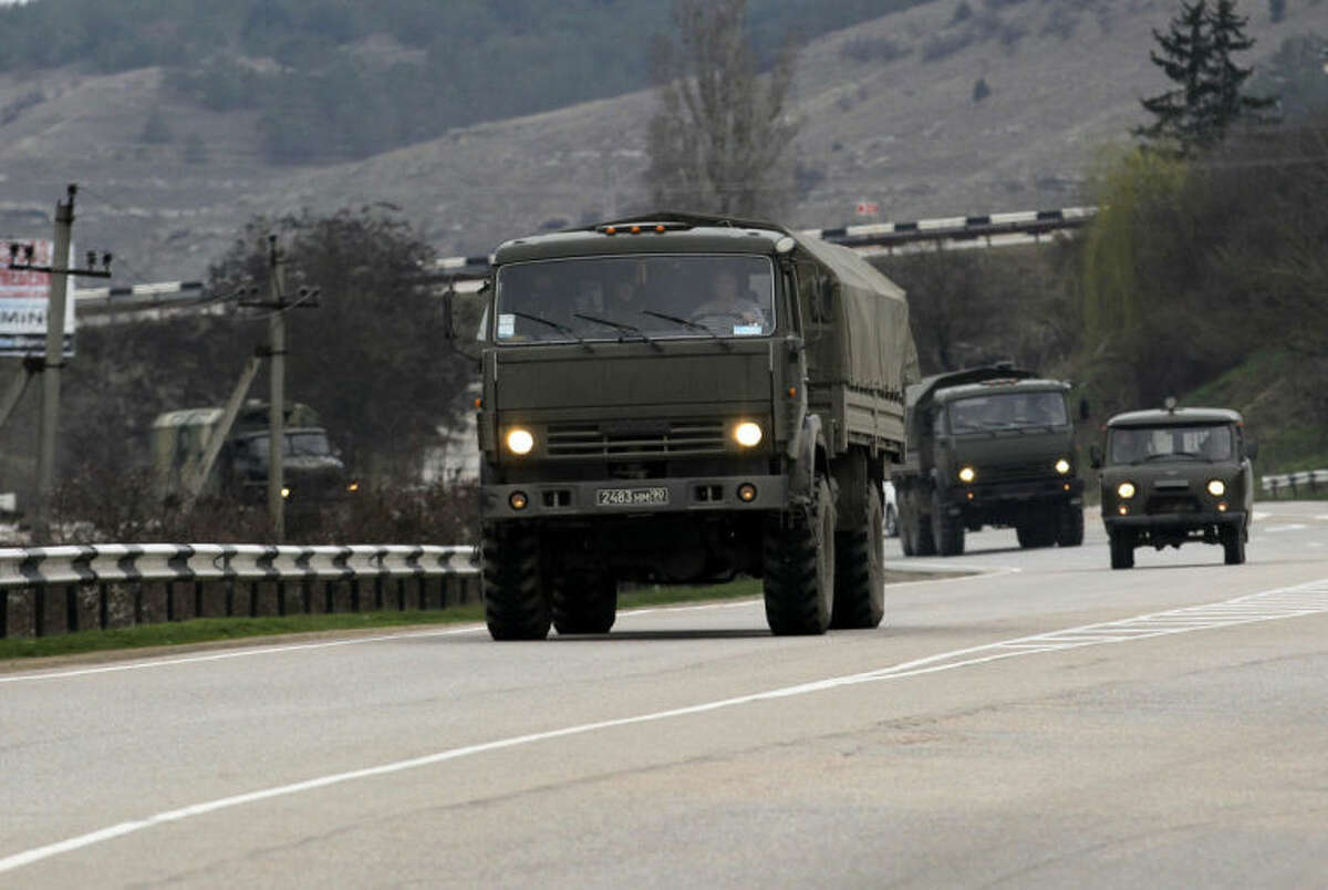 A Russian convoy moves from Sevastopol to Sinferopol in the Crimea, Ukraine, Sunday, March 2, 2014. A convoy of hundreds of Russian troops headed toward the regional capital of Ukraine's Crimea region on Sunday, a day after Russia's forces took over the strategic Black Sea peninsula without firing a shot. The new government in Kiev has been powerless to react. Ukraine's parliament was meeting Sunday in a closed session. (AP Photo/Darko Vojinovic)