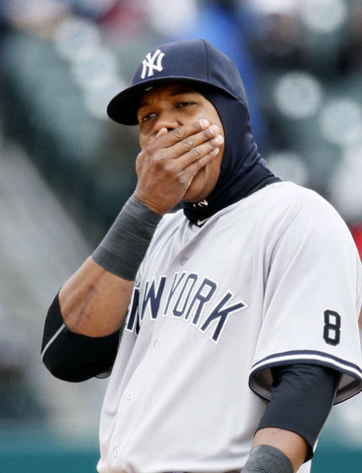 New York Yankees' Starlin Castro tries to keep his hand warm while playing second base against the Detroit Tigers during the fourth inning of a baseball game Saturday, April 9, 2016, in Detroit. (AP Photo/Duane Burleson)