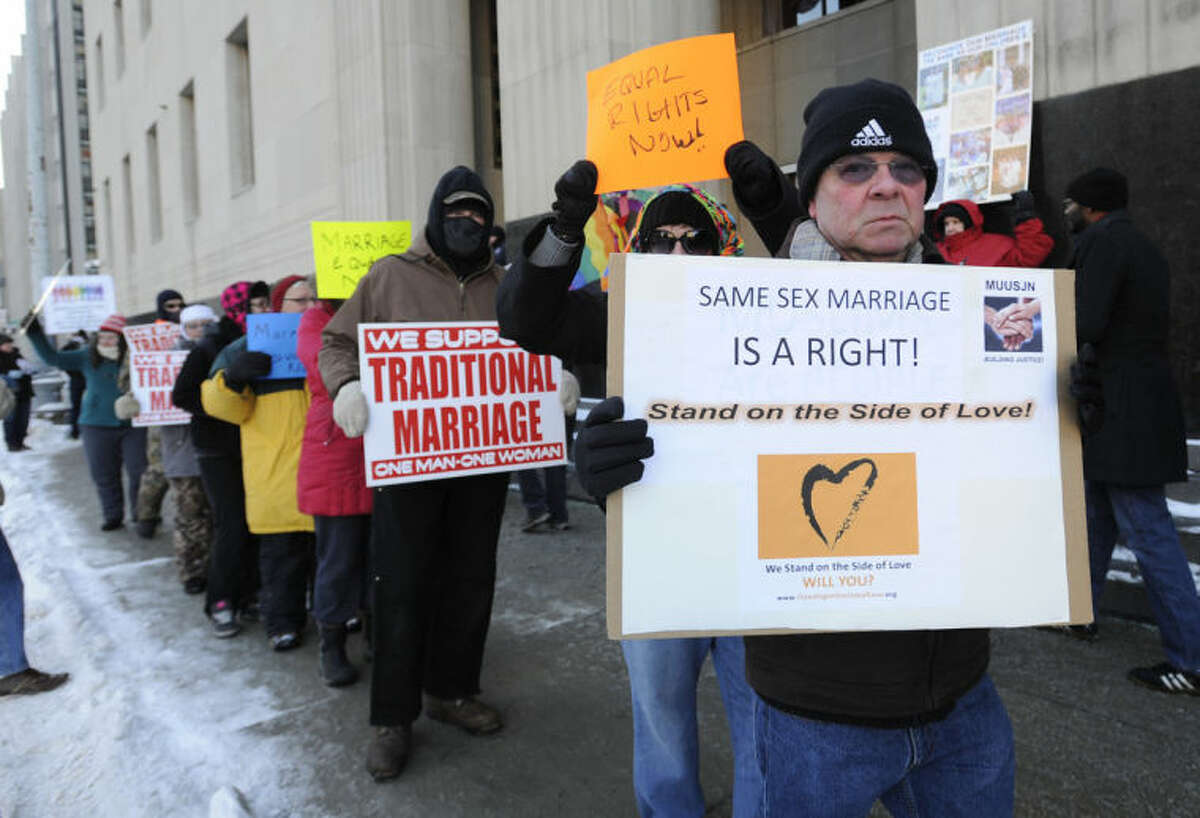 Protestors demonstrate outside Federal Courthouse before a trial that could overturn Michigan's ban on gay marriage in Detroit on Monday, March 3, 2014 in Detroit. Lisa Brown of Oakland County, the elected clerk of a Detroit-area county says she'll follow the orders of a judge when it comes to same-sex marriage, not Michigan's attorney general. Brown was asked about an email last fall from the attorney general's office, which warned county clerks not to issue marriage licenses to same-sex couples, even if a judge threw out the ban. Michigan voters banned gay marriage in 2004. In a lawsuit, Detroit-area nurses April DeBoer and Jayne Rowse say that violates the U.S. Constitution. (AP Photo/Detroit News, David Coates) DETROIT FREE PRESS OUT; HUFFINGTON POST OUT