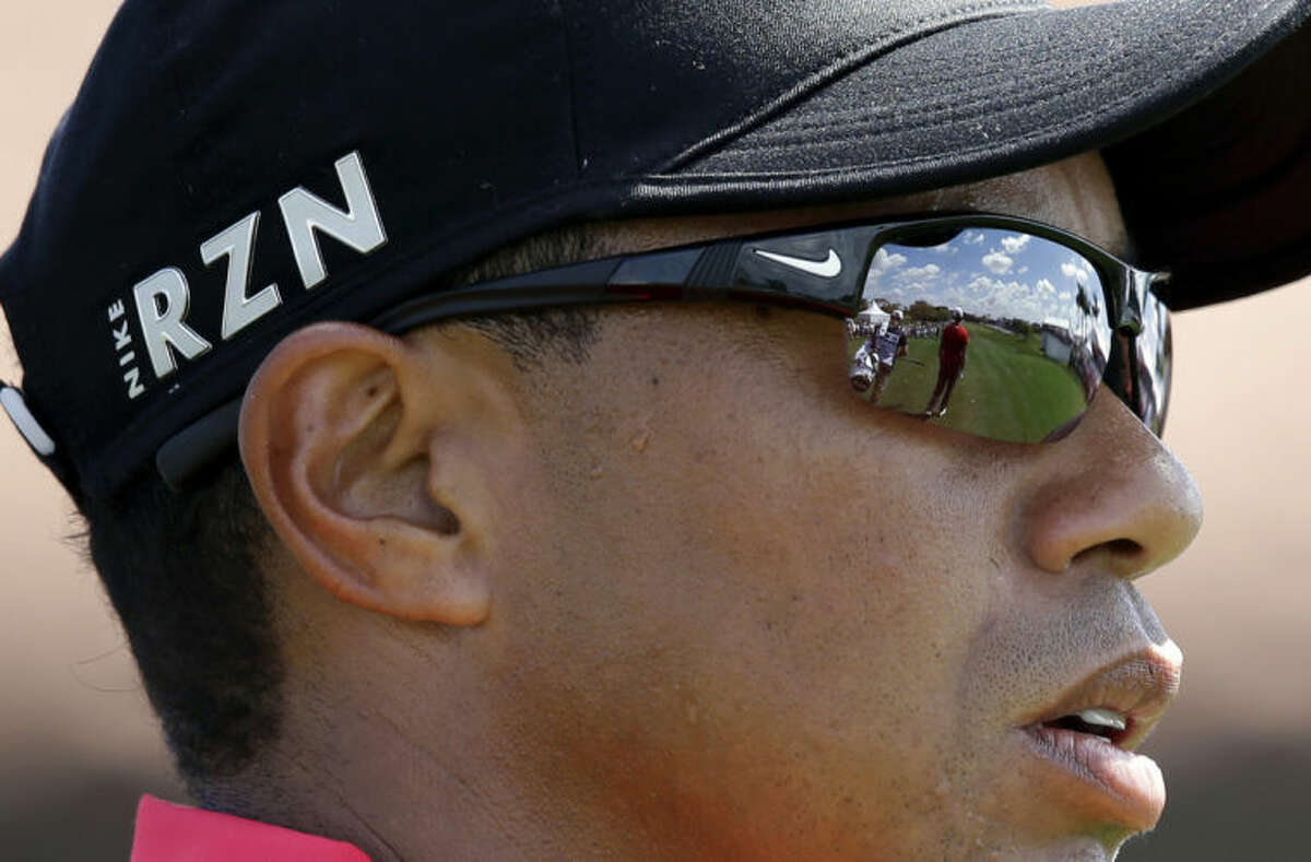 Tiger Woods watches as Luke Guthrie hits on the first hole during the final round of the Honda Classic golf tournament on Sunday, March 2, 2014, in Palm Beach Gardens, Fla. (AP Photo/Wilfredo Lee)
