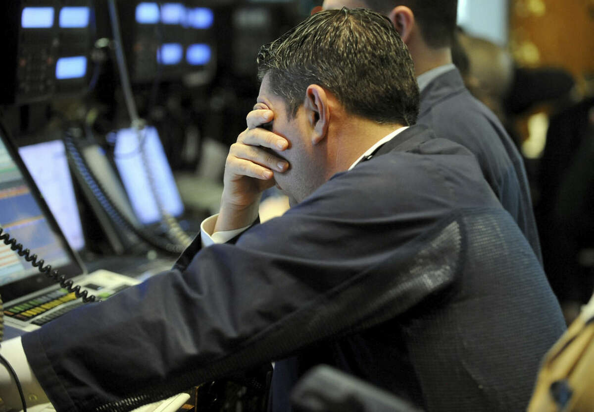 FILE - In this March 9, 2015, file photo, a trader covers his face while working on the floor of the New York Stock Exchange, in New York. The Standard & Poor’s 500 index has more than tripled since bottoming out at 676.53 on March 9, 2009. Since that low point, stocks have notched a series of gains without a drop of 20 percent of more. (AP Photo/Henny Ray Abrams, File)