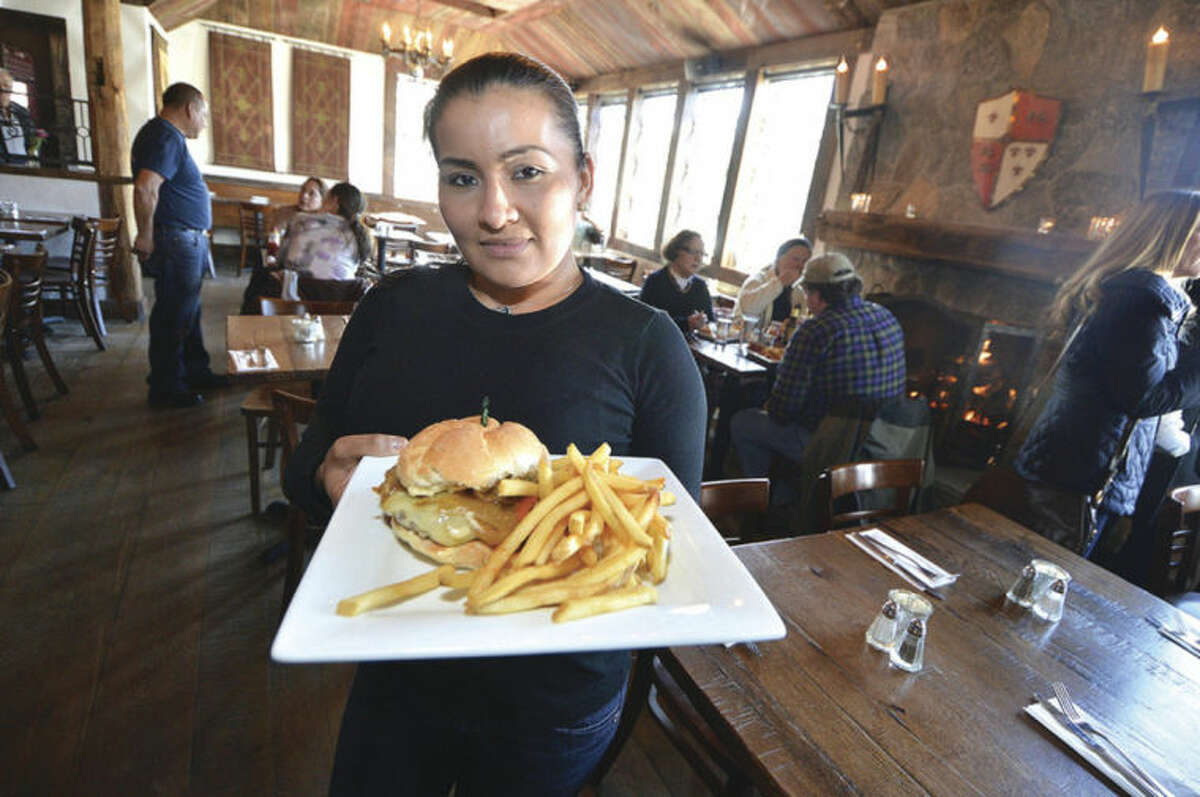 Hour photo / Alex von Kleydorff Server Marina Bonilla heads to the dining room with a Cajun Stout Burger with smoked bacon and tabasco at The Little Pub on Danbury Road. This is just one of the many Restaurant Week options for this coming week.
