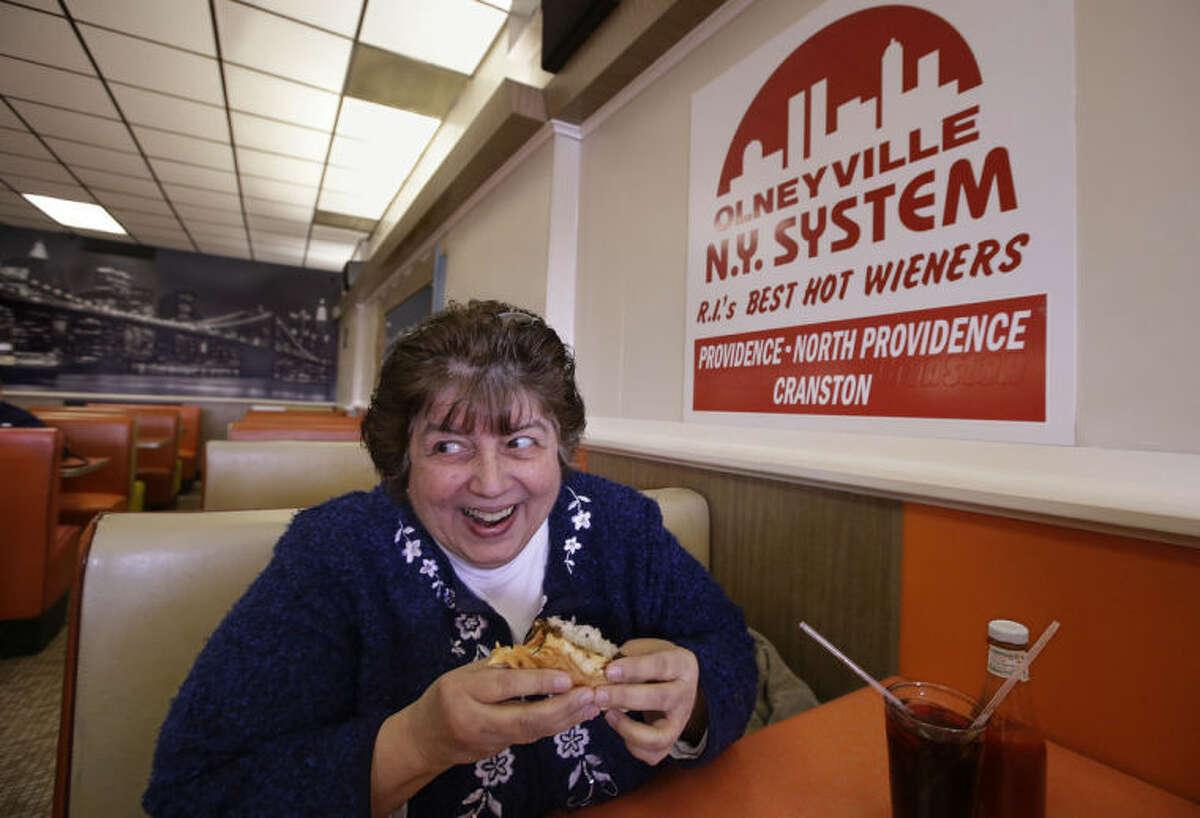 In this Monday, March 3, 2014 photo Judy Dexter prepares to take a bit of her hot wiener "all the way" at Olneyville New York System of Providence in Providence, RI. The James Beard Foundation named the Rhode Island restaurant one of five "American Classics" this year as best known for hot wieners, also called hot dogs. (AP Photo/Stephan Savoia)