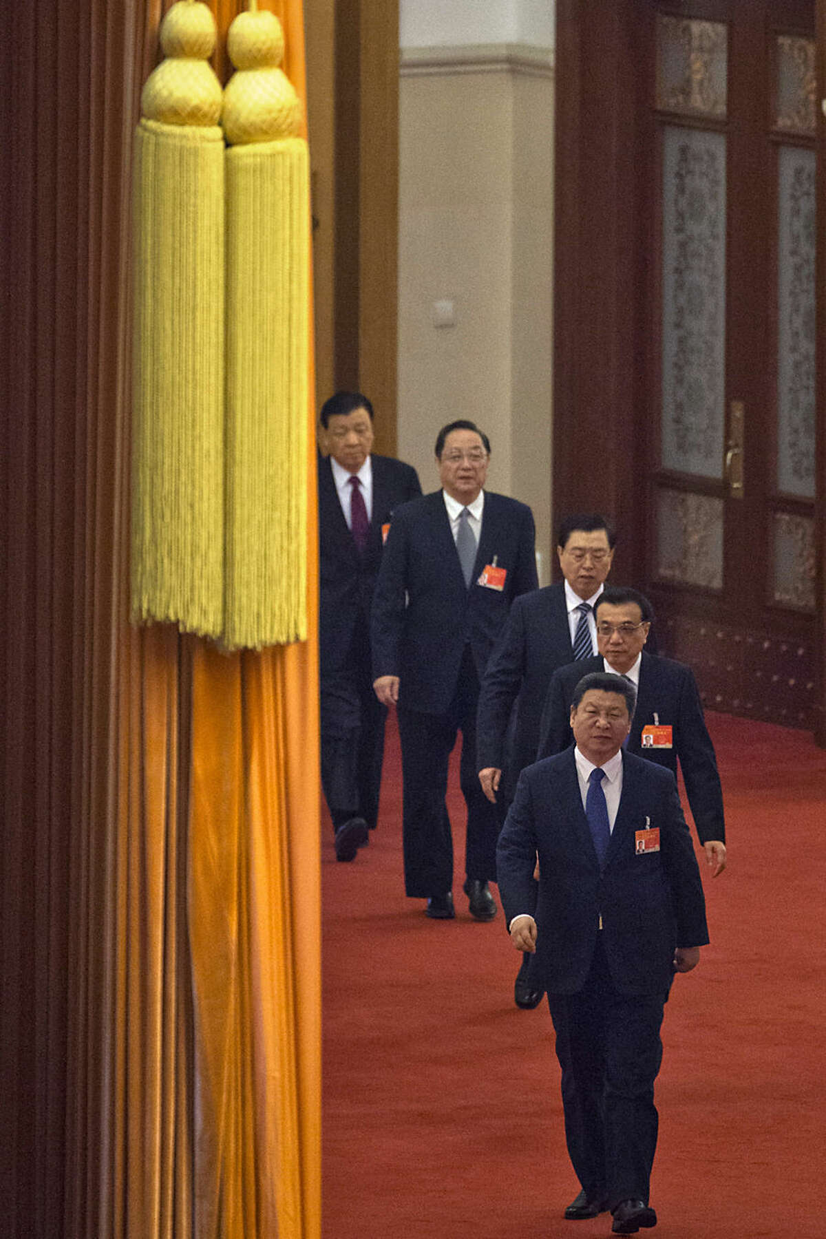 Chinese President Xi Jinping, front, leads the members of the Politburo Standing Committee as they arrive for a plenary session of the National People's Congress in the Great Hall of the People in Beijing Thursday, March 12, 2015. Behind Xi is Chinese Premier Li Keqiang and Politburo members Zhang Dejiang, Yu Zhengsheng and Liu Yunshan. (AP Photo/Ng Han Guan)