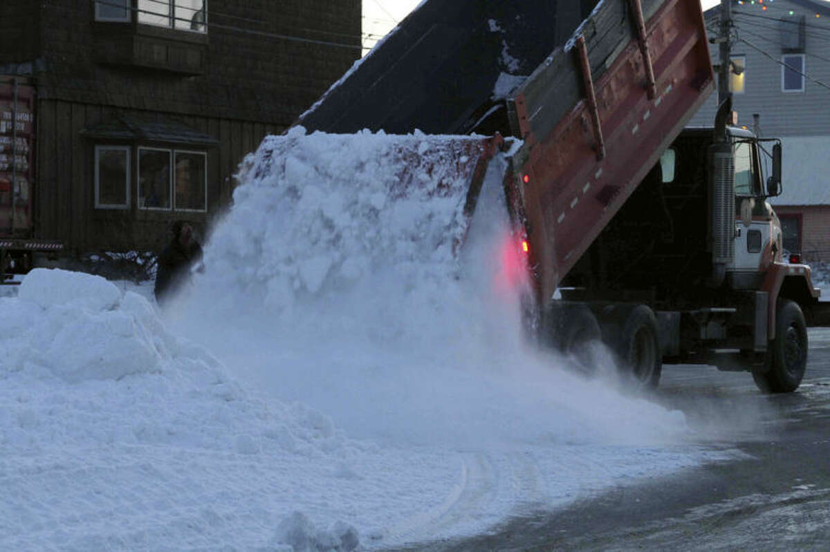 A Nome public works truck dumps a load of snow onto Front Street on Sunday, March 9, 2014, in Nome, Alaska. The snow was trucked in to provide a trail for mushers to the finish line of the Iditarod Trail Sled Dog Race. (AP Photo/Mark Thiessen)