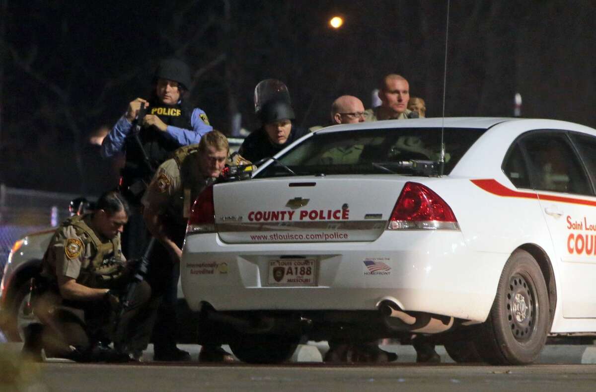 Police mobilize in the parking lot of the Ferguson Police Station after two police officers were shot while standing guard in front of the Ferguson Police Station on Thursday, March 12, 2015. (AP Photo/St. Louis Post-Dispatch, Laurie Skrivan)