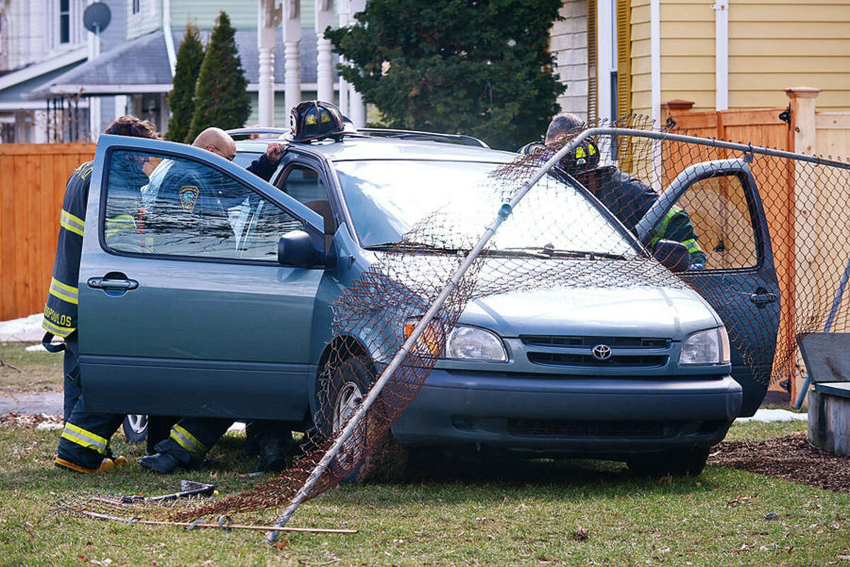 Hour photo / Erik Trautmann Emergency personnel respond to a motor vehicle accident on Gregory Boulevard where an elderly man drove his minivan across two lawns and through a chain link fence Wednesday afternoon.