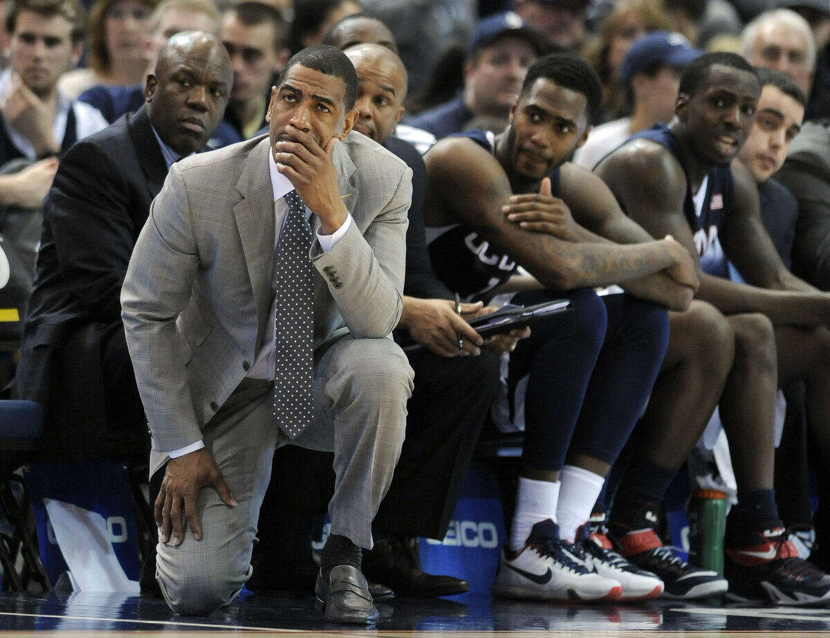 Connecticut head coach Kevin Ollie and his team react late in the second half of their 62-54 loss to SMU in an NCAA college basketball game in the finals of the American Athletic Conference tournament in Hartford, Conn., Sunday, March 15, 2015. (AP Photo/Fred Beckham)
