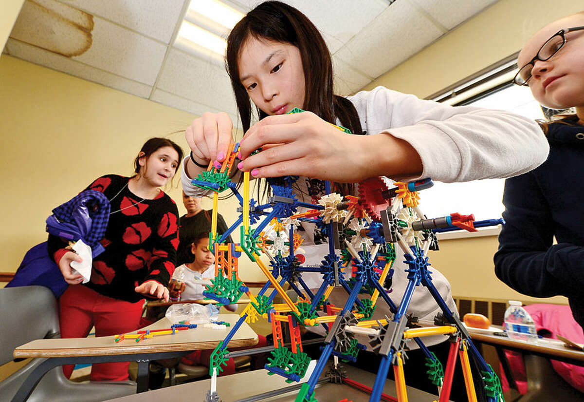 Hour photo / Erik Trautmann Caoillainn Bischoff puts the finishing touches on her K'Nex amusement park ride as the Norwalk Community College Extended Studies Division hosts The Amazing Girl Science Conference: Amusement Park Physics event for girls grades 4 to 8 Saturday at the college's East Campus. The Amusement Park Experience, part of the Saturday Academy for Girls, and the NCC College for Kids Program, provided students an opportunity to combine real-world applications with STEM concepts.