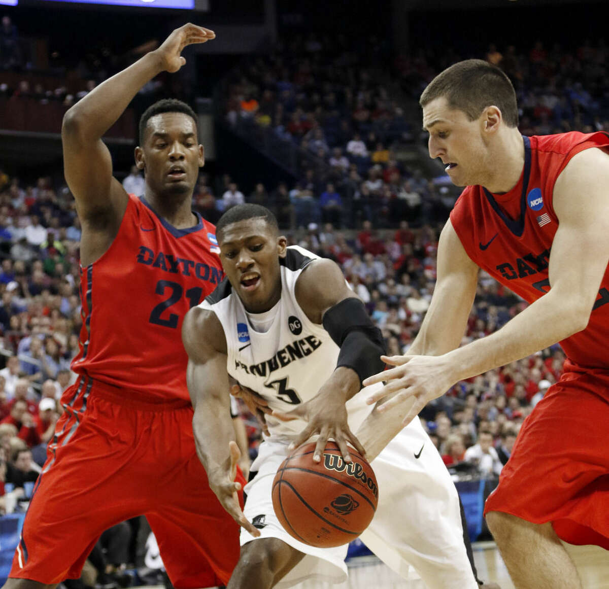 Providence's Kris Dunn (3) loses the ball against Dayton's Dyshawn Pierre, left, and Bobby Wehrli in the second half of an NCAA tournament college basketball game in the Round of 64 in Columbus, Ohio, Saturday, March 21, 2015. (AP Photo/Paul Vernon)
