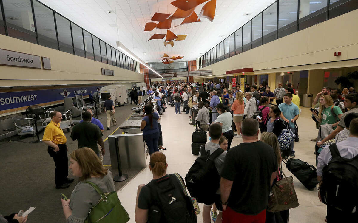 Long lines of fliers await word of their departures in the ticketing area of Louis Armstrong International Airport after a machete-wielding man was shot by a TSA employee on Concourse B on Friday, March 20, 2015. (AP Photo/NOLA.com The Times-Picayune, Michael DeMocker, Nola.com)
