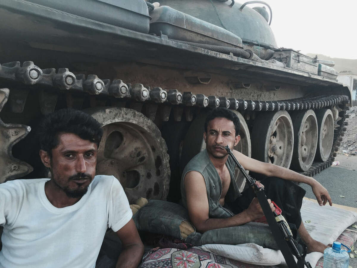Members of a militia group loyal to Yemen's President Abed Rabbo Mansour Hadi, known as the Popular Committees, chew qat, Yemen's favorite drug, as they sit next to their tank, guarding a major intersection in Aden, Yemen, Saturday, March 21, 2015. Yemen's Shiite rebels issued a call to arms Saturday to battle forces loyal to the embattled President Hadi, as U.S. troops evacuated a southern air base over al-Qaida militants seizing a nearby city, authorities said. (AP Photo/Hamza Hendawi)