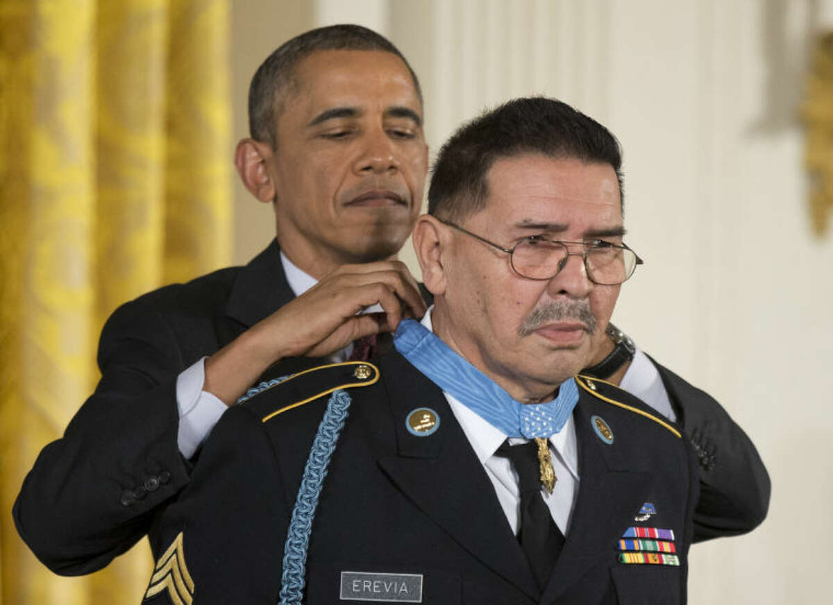 President Barack Obama awards Army Spc. Santiago Erevia the Medal of Honor during a ceremony in the East Room of the White House in Washington, Tuesday, March 18, 2014. President Obama awarded the Medals of Honor to 24 ethnic or minority U.S. soldiers who performed acts of bravery under fire in three of the nation?’s wars, that were denied because of prejudice. (AP Photo/Manuel Balce Ceneta)