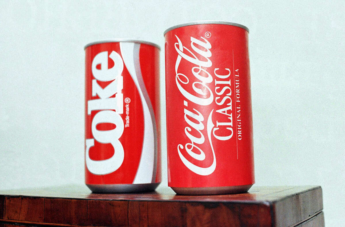 FILE - In this July 11, 1985 file photo, cans of New Coke and Coca-Cola Classic are on display during a news conference in Atlanta. New Coke's sweeter formula was a marketed as an improved replacement for the flagship soda, but the outcry was immediate and sustained. Coke tried to sell both versions for awhile, but eventually reverted to “Coca-Cola Classic.” (AP Photo/Charles Kelly, file)